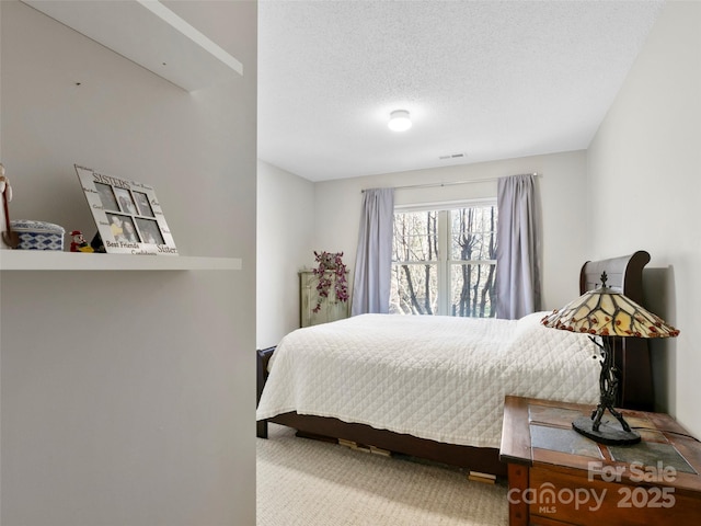 carpeted bedroom featuring a textured ceiling