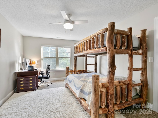 carpeted bedroom with ceiling fan and a textured ceiling