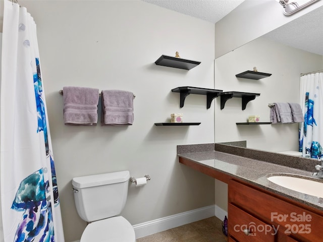 bathroom with vanity, toilet, and a textured ceiling