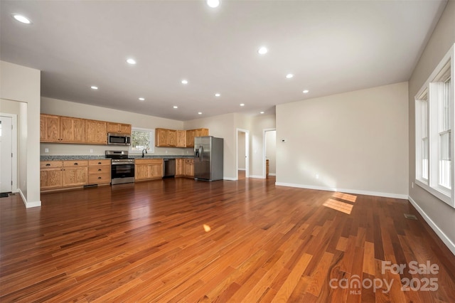 unfurnished living room featuring dark wood-type flooring and sink