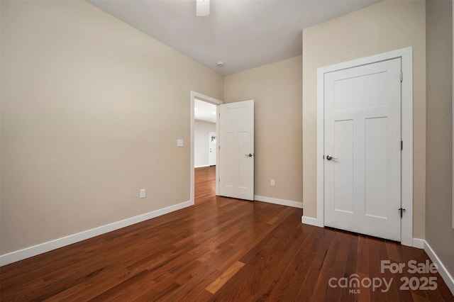 unfurnished bedroom featuring ceiling fan and dark hardwood / wood-style floors