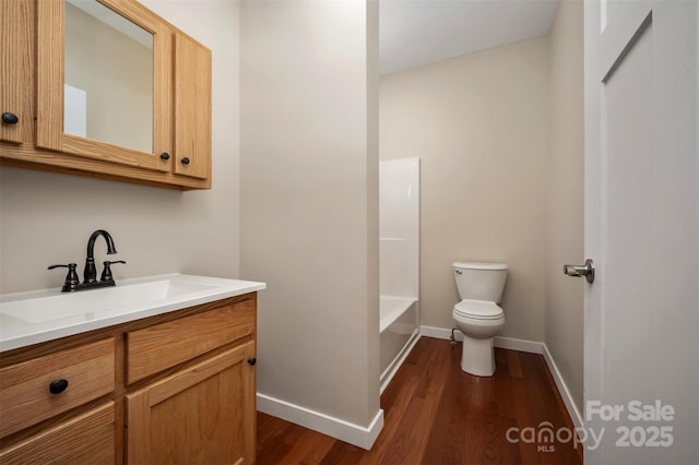 full bathroom with hardwood / wood-style flooring, vanity, toilet, and washtub / shower combination