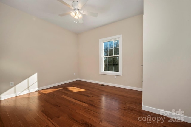 unfurnished room with dark hardwood / wood-style flooring and ceiling fan