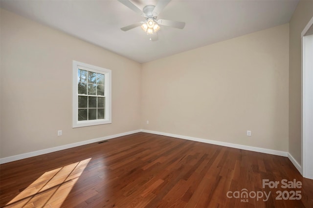 empty room with dark hardwood / wood-style flooring and ceiling fan