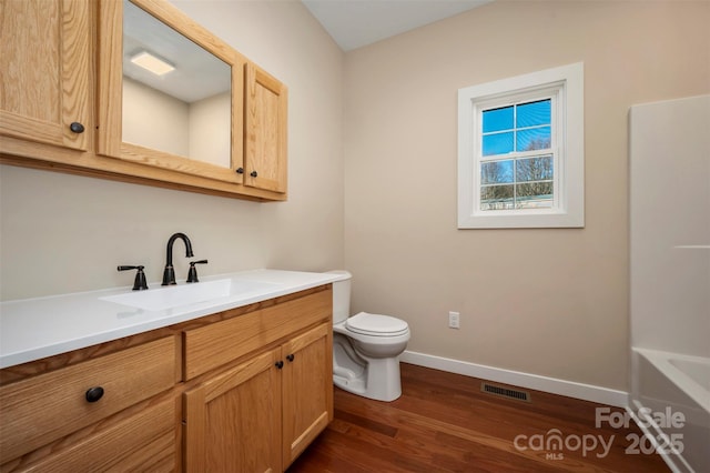 bathroom featuring toilet, vanity, and hardwood / wood-style flooring