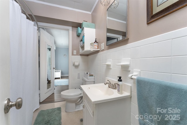 bathroom featuring crown molding, vanity, tile walls, and toilet