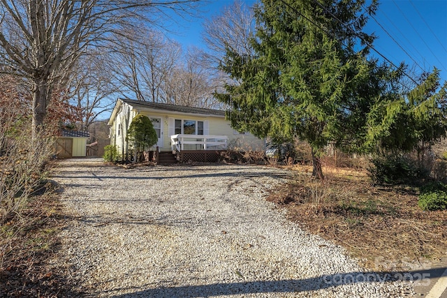 view of front of home with a shed and a wooden deck