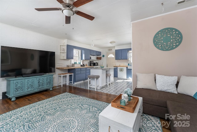 living room with ceiling fan and dark wood-type flooring