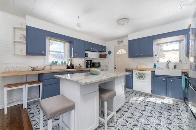 kitchen with dishwasher, a kitchen breakfast bar, blue cabinets, sink, and a kitchen island