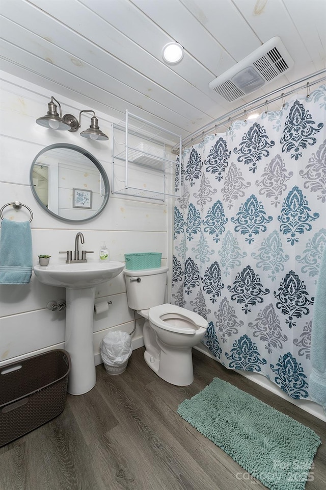 bathroom with hardwood / wood-style flooring, toilet, and wood ceiling