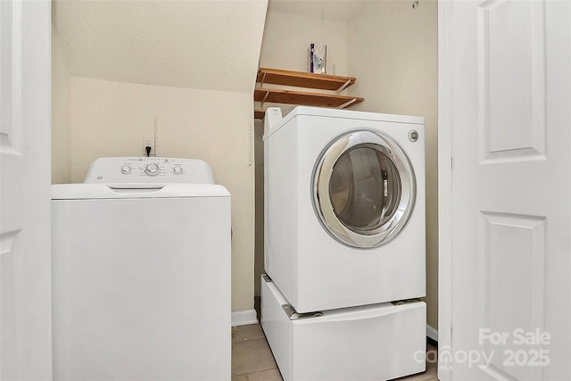 laundry room with light tile patterned floors, a textured ceiling, and independent washer and dryer