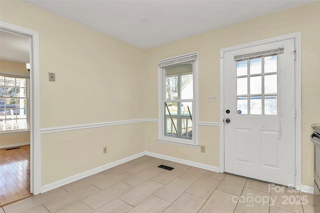 doorway to outside with light tile patterned flooring and a wealth of natural light