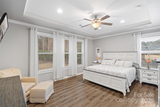 bedroom with ceiling fan, a tray ceiling, and crown molding