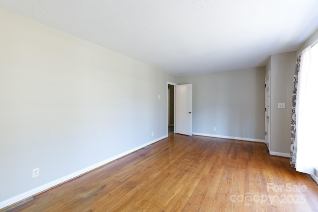 unfurnished room with hardwood / wood-style flooring