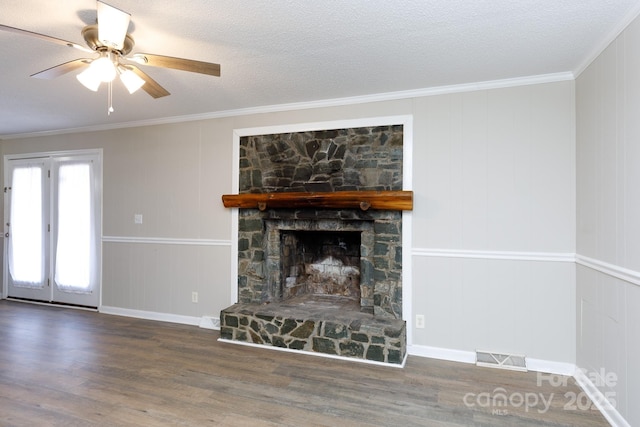 unfurnished living room with a textured ceiling, dark hardwood / wood-style floors, crown molding, and a fireplace