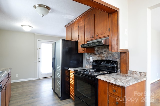 kitchen with tasteful backsplash, hardwood / wood-style flooring, a textured ceiling, and appliances with stainless steel finishes