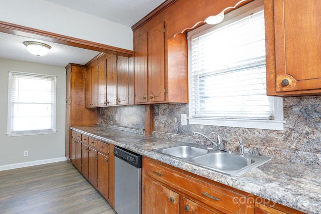 kitchen with dishwasher, sink, dark hardwood / wood-style flooring, a textured ceiling, and decorative backsplash