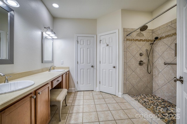 bathroom with a tile shower, tile patterned flooring, and vanity