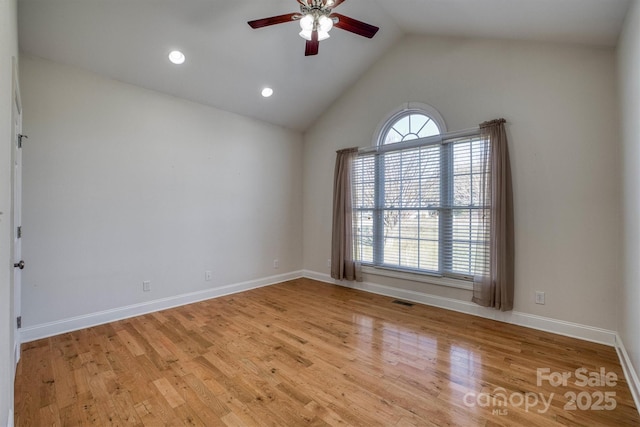 spare room featuring light wood-type flooring, vaulted ceiling, a healthy amount of sunlight, and ceiling fan