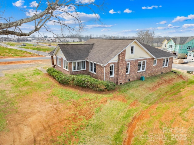 exterior space featuring brick siding, crawl space, a front lawn, and roof with shingles