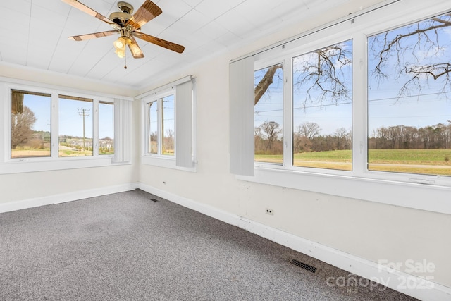 unfurnished sunroom with visible vents and ceiling fan