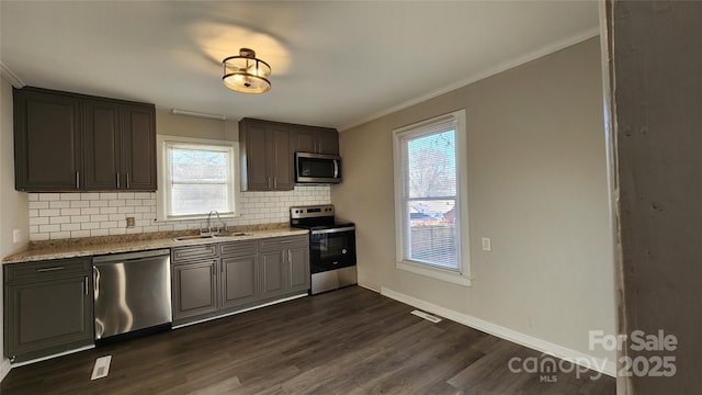 kitchen featuring decorative backsplash, appliances with stainless steel finishes, dark hardwood / wood-style floors, and sink