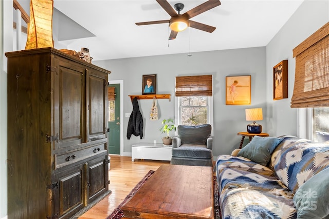 living room with ceiling fan and light hardwood / wood-style flooring