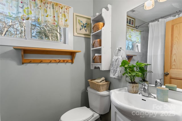 bathroom with toilet, vanity, a shower with curtain, and a wealth of natural light