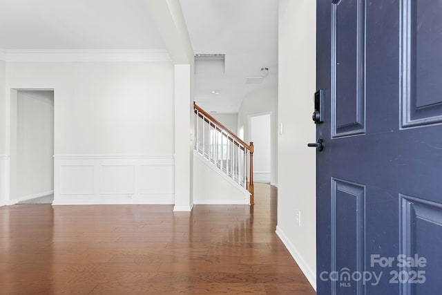 foyer with dark wood-type flooring and crown molding