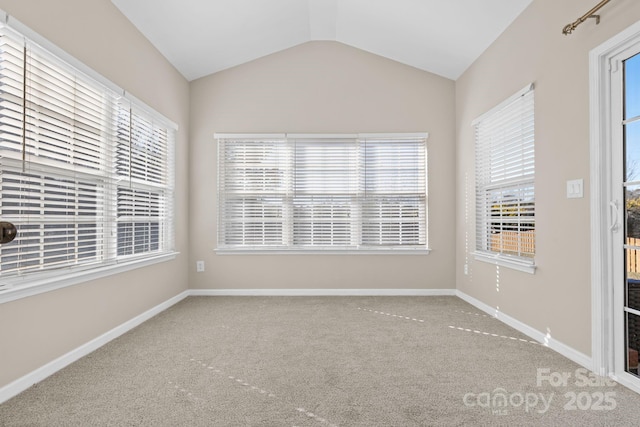 unfurnished room featuring carpet floors, a healthy amount of sunlight, and vaulted ceiling