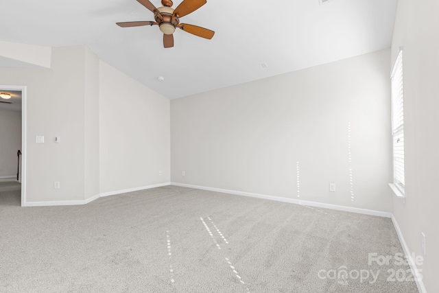 empty room featuring vaulted ceiling, ceiling fan, and carpet floors