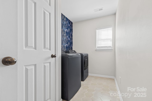 laundry area featuring light tile patterned flooring and washing machine and clothes dryer