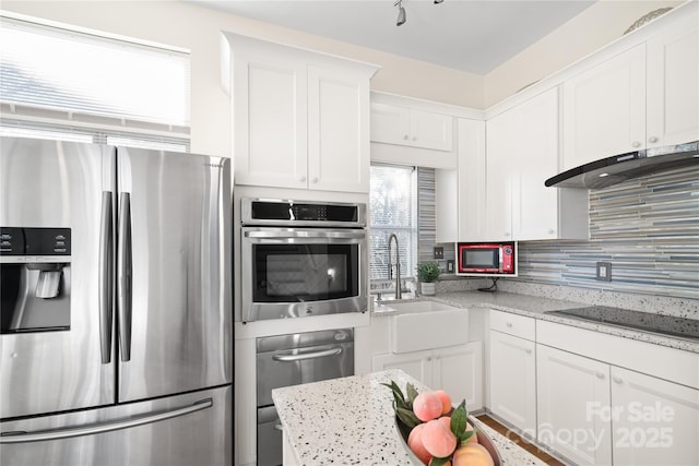 kitchen with white cabinets, light stone countertops, sink, and stainless steel appliances