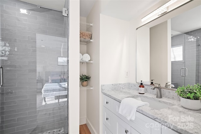 bathroom with vanity, a shower with door, and hardwood / wood-style floors