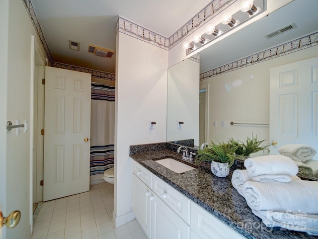 bathroom featuring tile patterned floors, vanity, toilet, and curtained shower