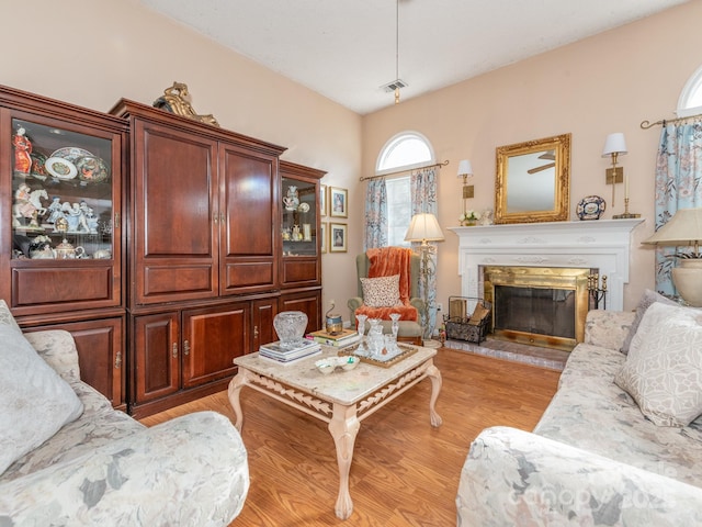 living room with light hardwood / wood-style floors and a premium fireplace