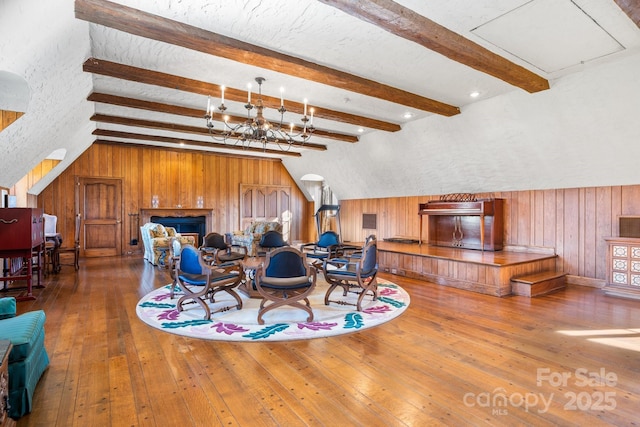 interior space with hardwood / wood-style flooring, a chandelier, lofted ceiling with beams, and a textured ceiling