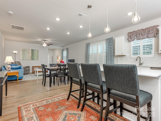 interior space with sink, ceiling fan, and light hardwood / wood-style flooring