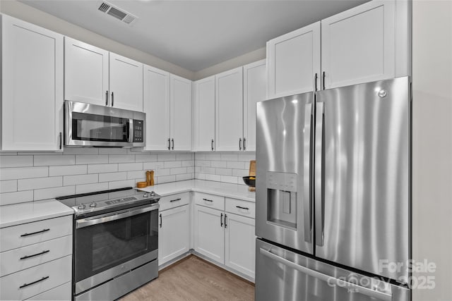 kitchen with appliances with stainless steel finishes and white cabinetry