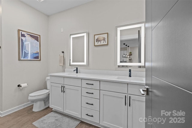 bathroom featuring toilet, vanity, and hardwood / wood-style flooring