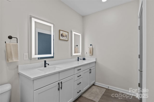 bathroom with toilet, vanity, and hardwood / wood-style floors