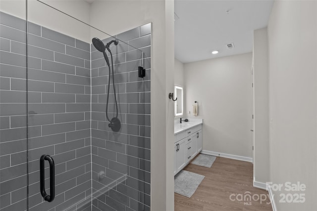 bathroom featuring wood-type flooring, vanity, and a shower with shower door