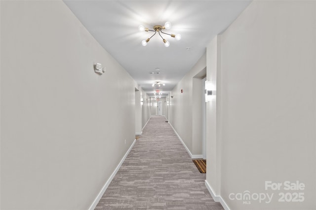 hall featuring an inviting chandelier