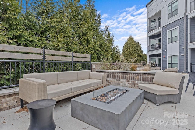 view of patio with an outdoor living space with a fire pit