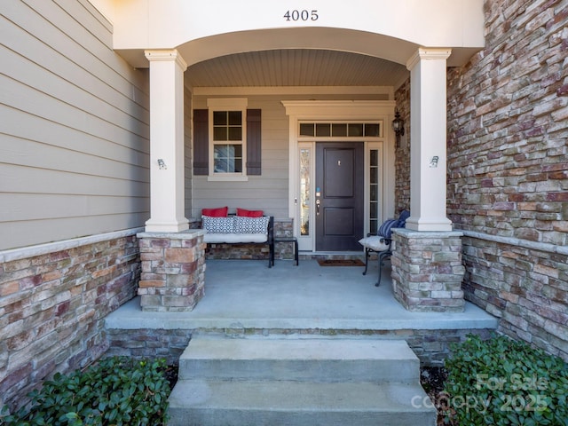 view of exterior entry featuring covered porch