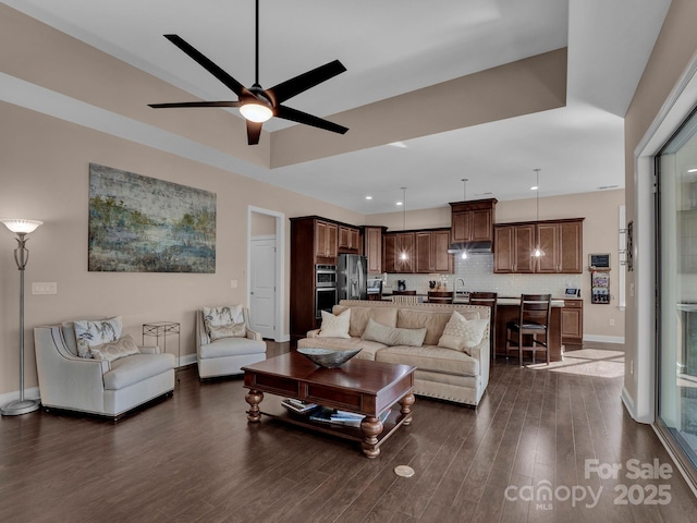 living room with ceiling fan and dark wood-type flooring