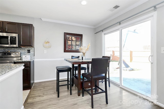 dining space featuring light hardwood / wood-style floors and ornamental molding