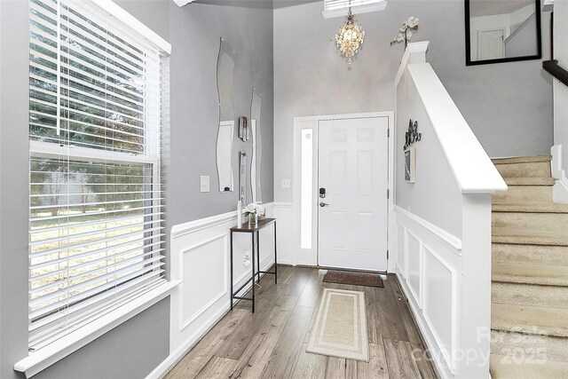 entryway with wood-type flooring and an inviting chandelier