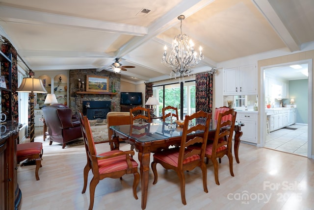 dining space with vaulted ceiling with beams, ceiling fan with notable chandelier, light hardwood / wood-style floors, and a fireplace