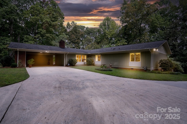 ranch-style home featuring a carport and a yard